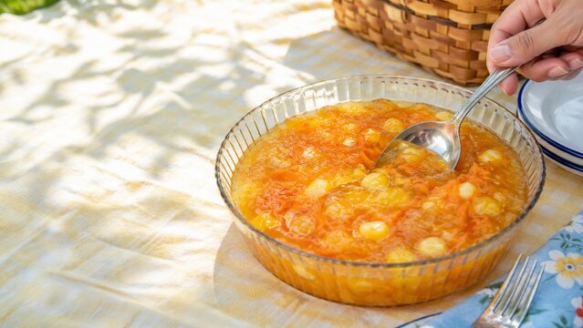Jello salad in a glass dish on picnic table with a plaid cloth