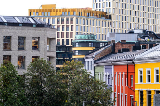Seen across the city center, colorful rooftops gather above historic facades as modern architecture builds urban contrast across Oslo, Norway.