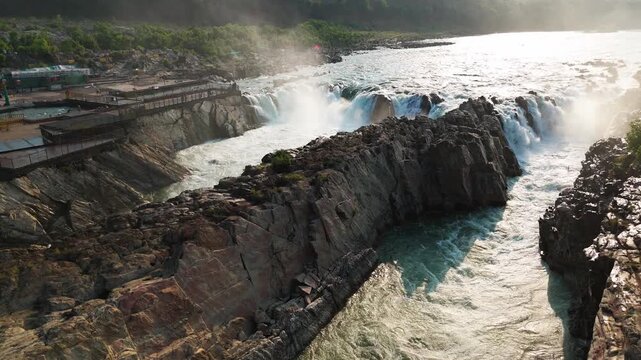 Jabalpur, Madhya Pradesh, India - April 01, 2026: Editorial drone footage flying smoothly forward to reveal Dhuandhar Waterfall, the Narmada River, marble gorge, rocky cliffs and riverside viewing pla