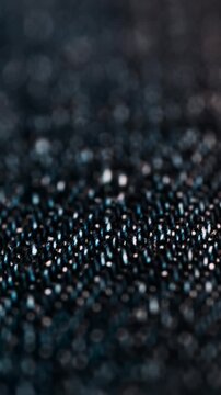 Macro view of dark denim fabric texture moving slowly under studio light.