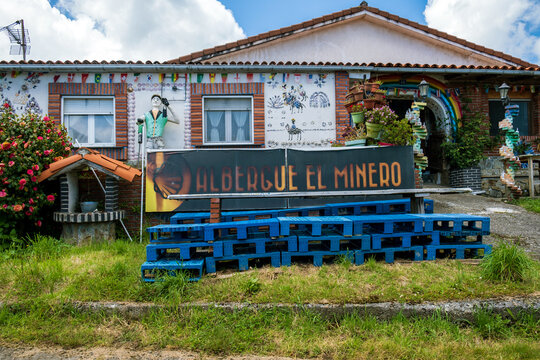 La Pereda, Asturias, Spain - May 16, 2025: Colorful decorated facade and sign of the Albergue El Minero pilgrim hostel along the Camino Primitivo.