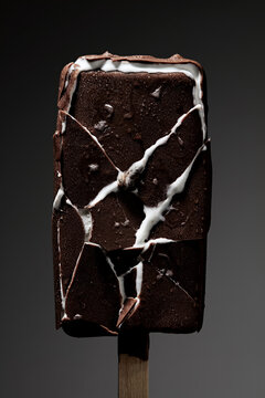 Cracked chocolate ice cream bar on a wooden stick