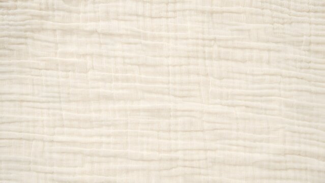 Closeup texture of soft beige muslin cotton fabric with natural wrinkles and crinkled pattern