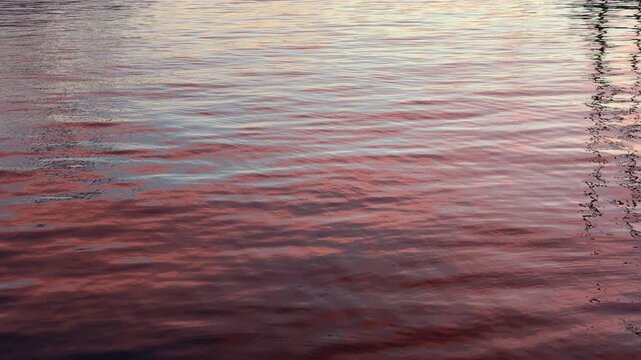 Abstract close up of the Bosphorus water surface rippling under a deep red and maroon sunset glow