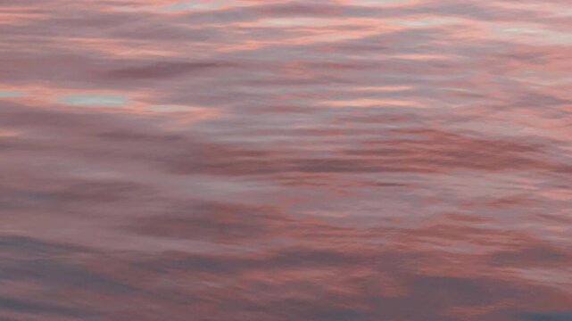 Close up of gentle waves reflecting a pink and mauve sunset sky on the surface of the Bosphorus