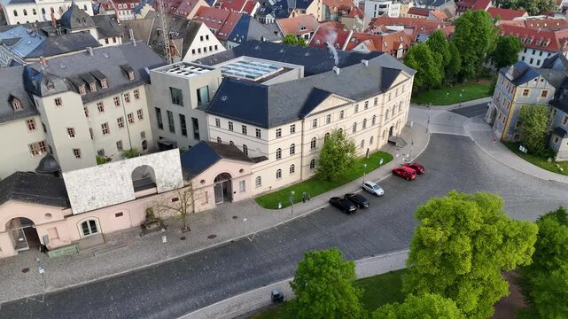 Drone descends from treetops toward the entrance area of the famous library complex