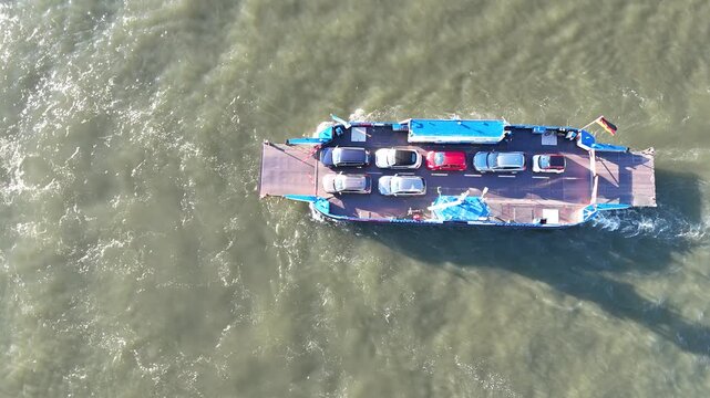Drone looks straight down on the ferry, highlighting churned water and wake patterns from a pure overhead perspective.