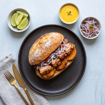 Peruvian Pan con Chicharr&oacute;n on Pastel Ceramic Background, Top View Minimal Food Photography
