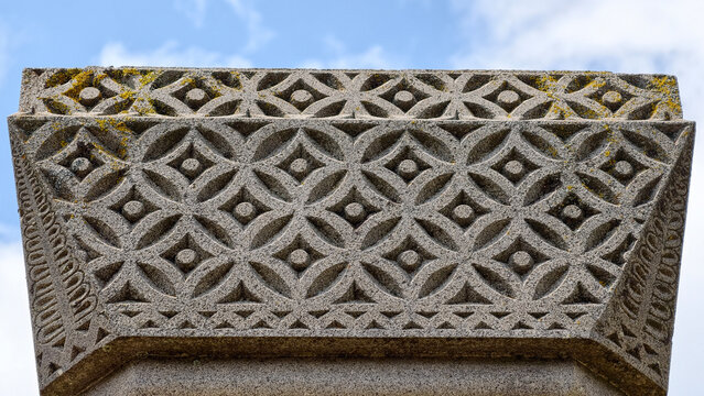 Ornate stone carving from ancient architecture. Featuring intricate geometric patterns. A detailed relief frieze. And traditional design elements