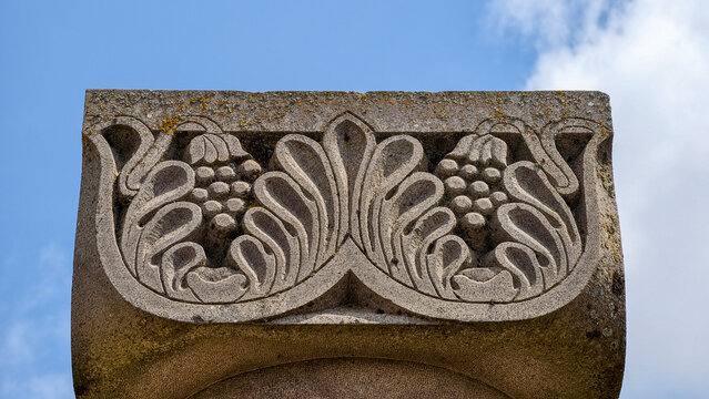 Zvartnots cathedral detail featuring an ancient armenian stone column capital with intricate carvings of grapevines and foliage