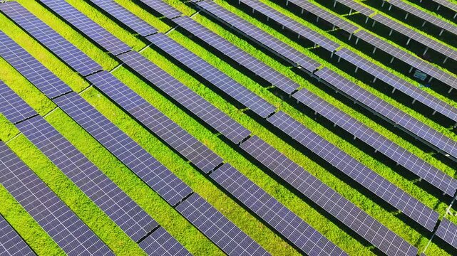 Drone flying over diagonal rows of solar panels