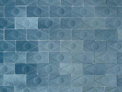 Blue geometric tile wall texture with diamond and circle pattern. Modern ceramic facade background.