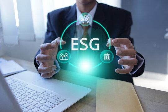 Businessman Hand Gesture Around ESG Graphic next to Laptop inside Office Room