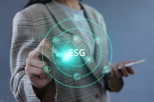 Businesswoman Holding Smartphone while Touching ESG Hologram with Stylus Pen