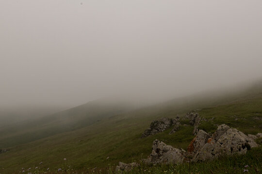 Foggy Mountain Meadow with Rocky Landscape and Misty Hills in Armenia
