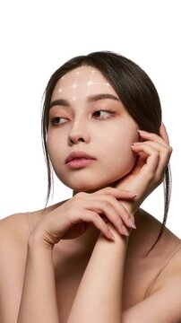 Young dark-haired woman with animated facial mapping grid in clean beauty portrait. Concept of AI skin diagnostics, personalized skincare technology, noninvasive cosmetic assessment.