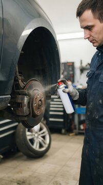 Mechanic Performing Precision Brake Cleaning and Maintenance on a Vehicle in a Modern Automotive Workshop Environment
