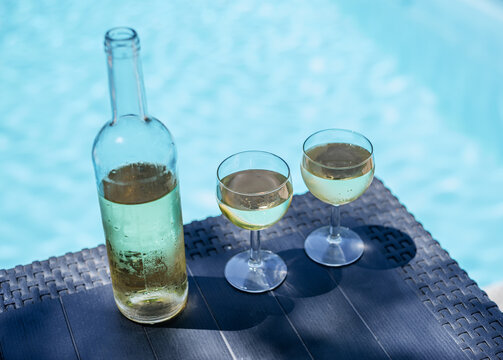 Bottle and two glasses of white wine on outdoor table