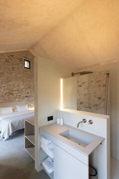 The interior of a bathroom in a bedroom. A very small but romantic space. A grey, brand-new washbasin.