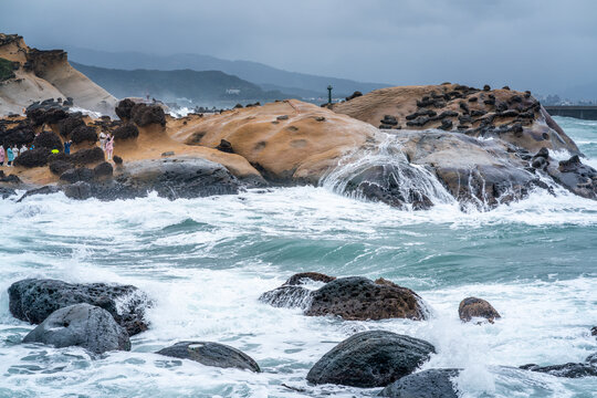 Scenic view of hoodoo stones rock formation and turbulent waters in Yehliu geopark in New Taipei Taiwan