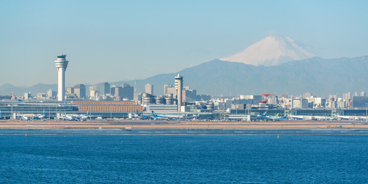 Tokyo Haneda airport and control tower with snowy mount Fuji in background with winter morning light in Tokyo Japan