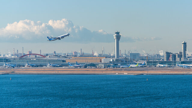Tokyo Haneda airport and control tower with ANA airline plane taking off in Tokyo Japan