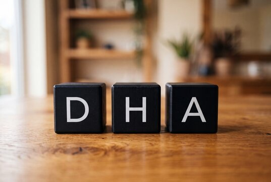 Three black wooden blocks spelling DHA arranged on a wooden table in a home setting