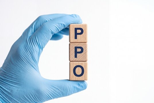 A medical professional in a blue latex glove holds a stack of wooden blocks spelling PPO, representing a Preferred Provider Organization health insurance plan.