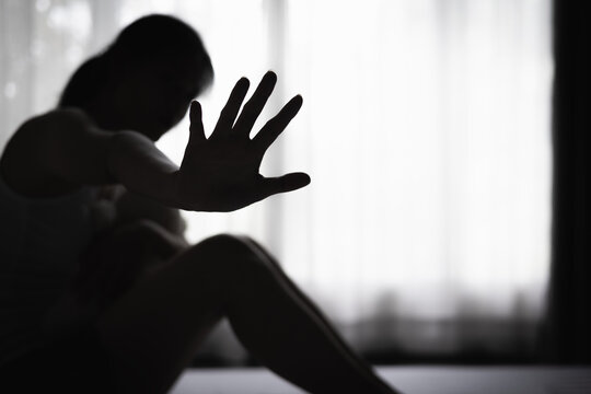 Strong woman raising her hand for awareness and positive change. Women's rights, survivor empowerment, trafficking prevention, protection, safety, hope, equality, and dignity.