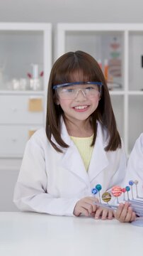 Elementary Student in Lab Coat Presenting Solar System Model