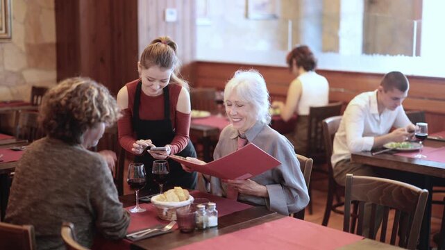 Waitress takes order from couple elderly man and woman. High quality 4k footage