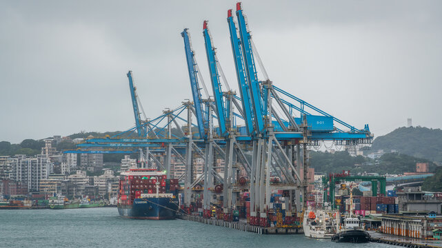 Scenic view of Keelung port with large dockside container crane and container ship in Keelung harbor Taiwan