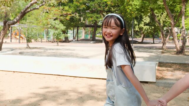 Two Young Asian Sisters Holding Hands and Running in Lumpini Park