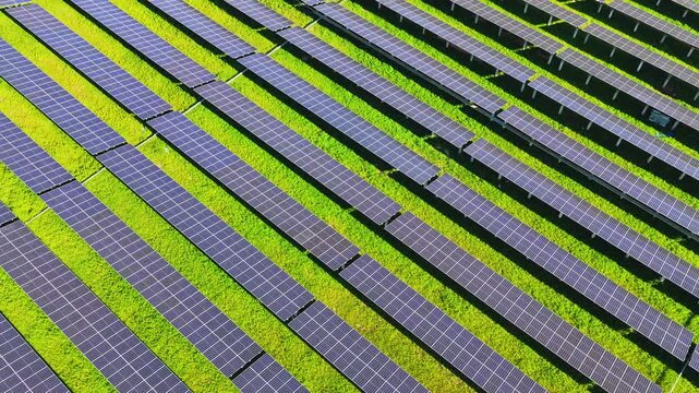 Drone flying over diagonal rows of solar panels
