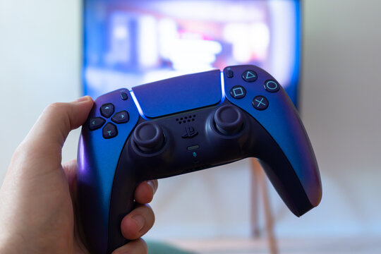 Yerevan, Armenia - 08.01.2026: Close-up of a purple Sony PlayStation 5 DualSense wireless controller. A guy plays a console at home holding a gamepad. Sony PS5 gamepad.