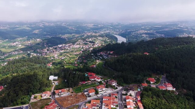 Aerial - red roofed houses of Castelo de Paiva on wooded hills above the Douro valley