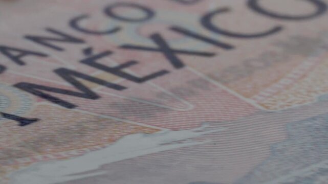 Macro close up of a Mexican 50 peso banknote highlighting the printed denomination, engraved details and security features during slow camera movement