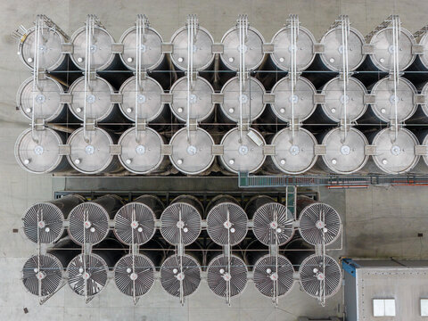 Aerial view of stainless steel tanks for petrochemical products arranged in rows at an industrial facility in Poland.