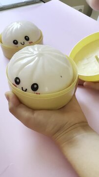 Unboxed Kawaii Dumpling Stress Relief Toy in Hand, Pink Background