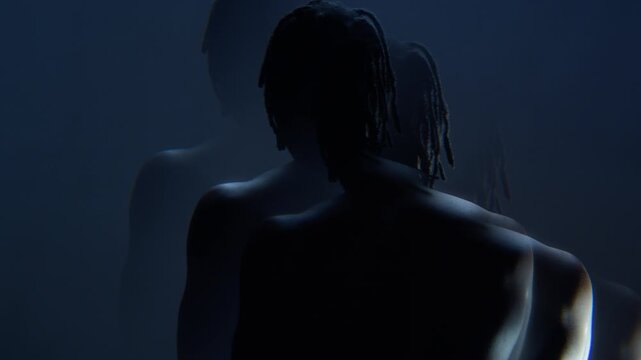 African American young adult man with dreadlocks moving hands in slow motion, captured through prism glass reflection. Ideal for mental health campaigns, psychology, or creative music videos