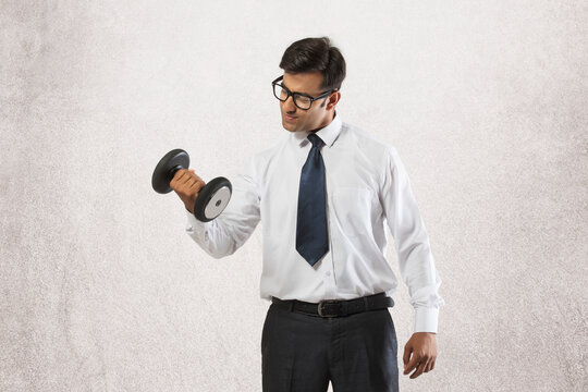 Young businessman lifting dumbbell