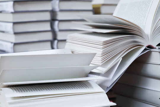 stack of books, close up. Open book on the table in library. Back to school concept. Open book on table with blur bookshelf background