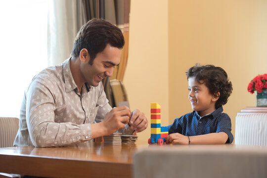 Father and son playing game with cards and building blocks