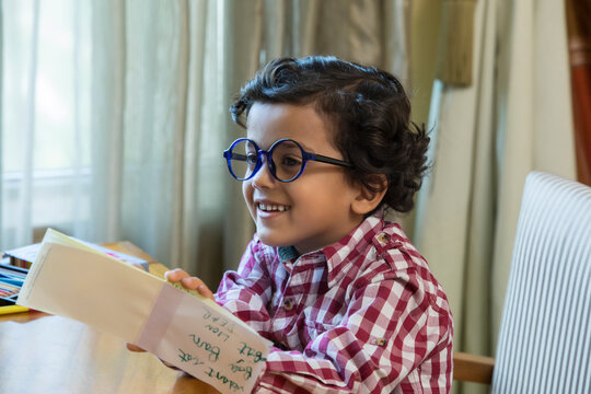 Boy with big round glasses doing his homework