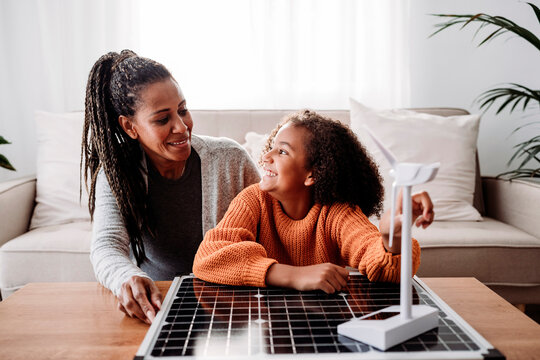 Happy mother and daughter sitting with renewable energies at home