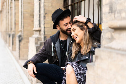Young couple sitting outdoors having fun