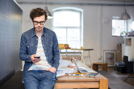 Man using cell phone in office