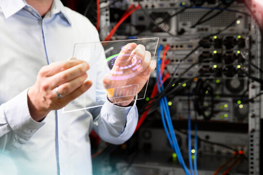 Close-up of engineer using wireless technology while standing in server room