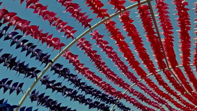 Colorful pinwheels spinning in the wind against a bright blue sky