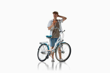 Fototapeta premium Young cyclist looks into distance while standing over bicycle. Concept of route discovery and navigation, future travel planning, independent urban exploration.